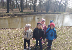 Dzieci przy stawie w którym pływają kaczki